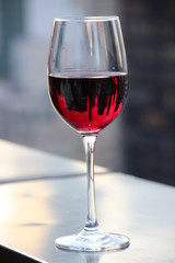 Silhouettes d'immeubles dans un verre de vin rouge