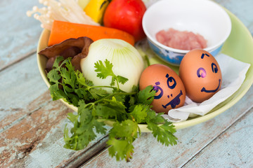 Fresh vegetables, eggs and pork chops. On blue wooden