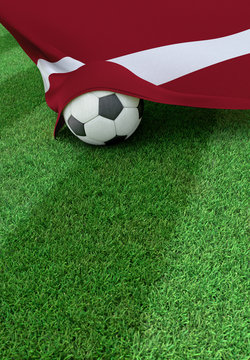 Soccer ball and national flag of Latvia,  green grass