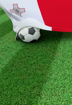 Soccer ball and national flag of Malta,  green grass
