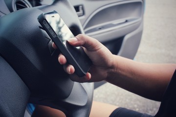 Woman using smart phone in the car.