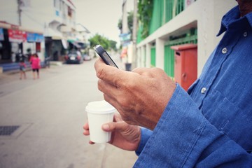 Man drink coffee paper cup with smart phone