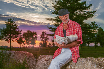 Senior man reading newspaper and enjoy in sunny day.