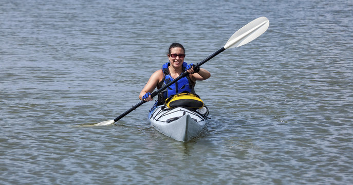 Young Woman Paddling A Kayak