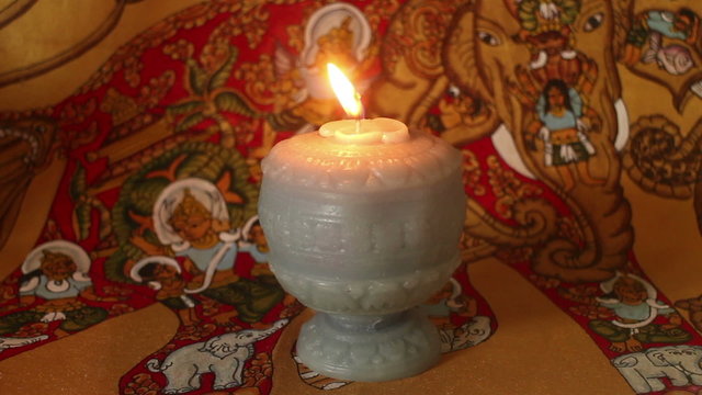 Medium Close up of Burning Candle against Exotic Background (Static)
