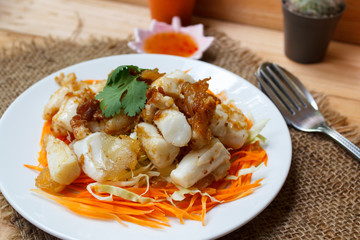 Fried squid serve with vegetable and sauce.