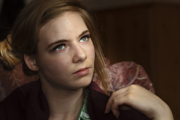 Portrait of a beautiful young woman looking up with her face lit by dramatic lighting