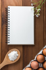 Notebook white on a wooden floor with egg dishes.