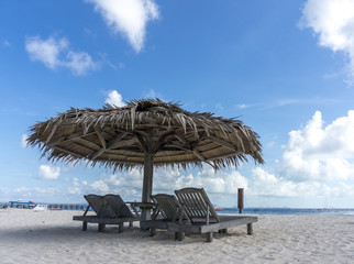 Fototapeta premium Dreamy beach with sun loungers under a beach umbrella at Mabul, Semporna Sabah.