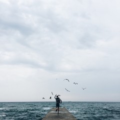 Fototapeta na wymiar lonely man silhouette run on the sea pier in the storm