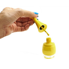 Naklejka premium female hand dropping nail polish into nail polish bottle isolate