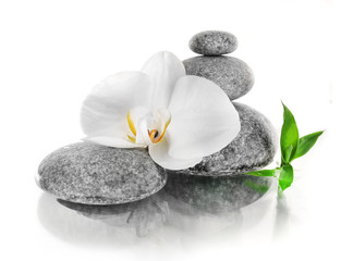 Obraz na płótnie Canvas Stack of spa stones with orchid flower isolated on white