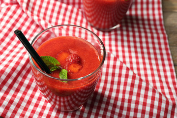 Glasses of strawberry smoothie with berries on table close up