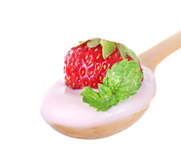 Delicious yogurt in spoon with strawberry and mint isolated on white