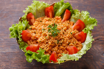 Kisir, traditional turkishr salad, Bulgur wheat   prepared with tomato paste, fresh tomatoes, parsley, olive oil.selective focus