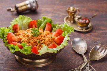 Kisir, traditional turkishr salad, Bulgur wheat   prepared with tomato paste, fresh tomatoes, parsley, olive oil.selective focus