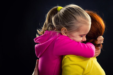 Little girl hugs her mother