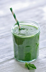Glass of spinach juice on wooden background