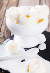 Ice cream, white cream in a white ceramic bowl with white roses.selective focus