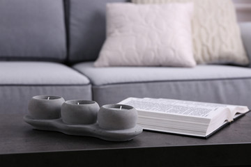 Book and candlestick on table on Modern sofa  background