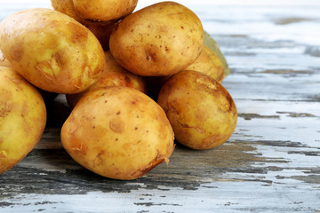 Young potatoes on wooden table close up