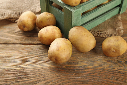 Young potatoes in crate on table close up
