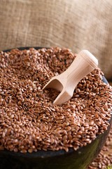 Wooden spoon in marble bowl with flax seeds