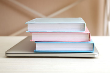 Stack of books with laptop on table close up