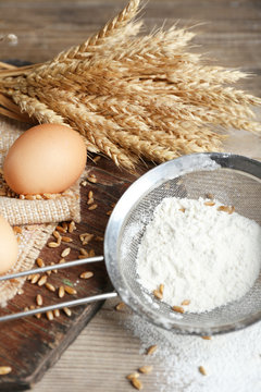 Flour and wheat on wooden table, closeup