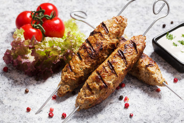 Barbecued kofta - kebeb with vegetables on a plate.