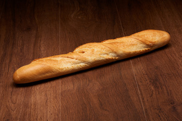 French baguette bread on dark wooden table background