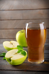 Glass of apple juice on wooden background