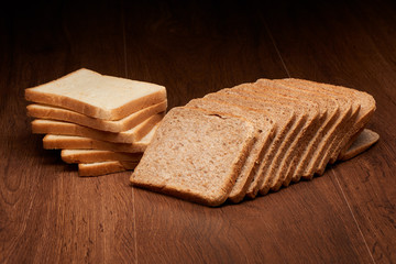 Different sliced bread on dark wooden table background