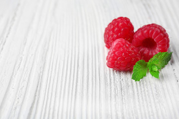 Fresh red raspberries on wooden background