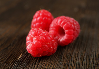 Fresh red raspberries on wooden background