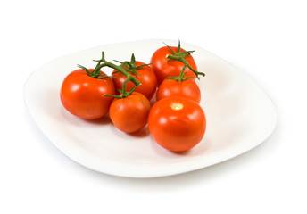  tomatoes on a plate on a white background
