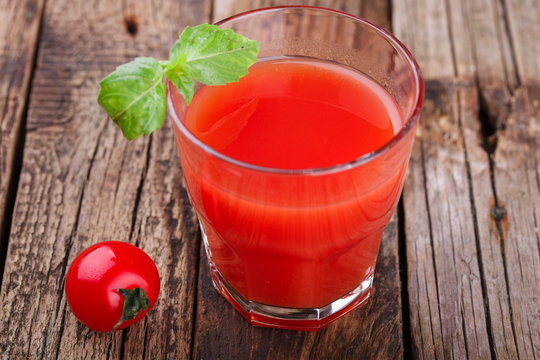 Tomato juice in a glass beaker. Vine tomatoes and Basil.selective focus