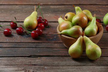 Ripe pears and cherries on wooden table close up