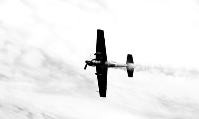 historic warplane with dark smoke from the engine malfunction