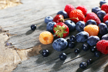 Heap of sweet tasty berries on wooden table close up