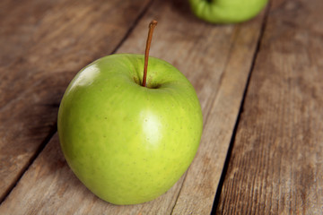 Ripe green apples on wooden table close up