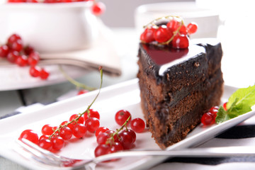 Tasty chocolate cake with berries on table close up