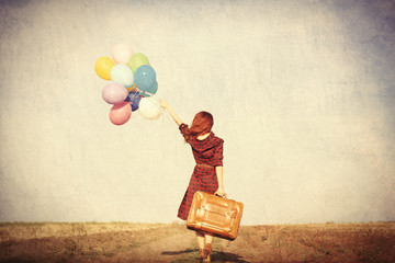 girl with multicolored balloons and bag