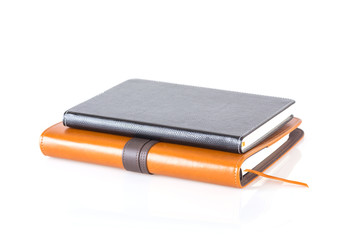 brown and black leather diary books.