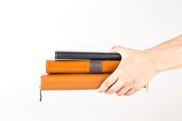 brown and black leather diary books in hand.