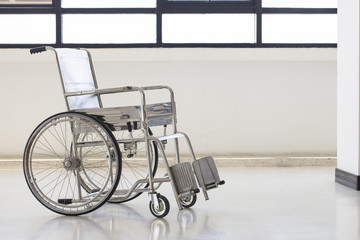 Fototapeta na wymiar Empty wheelchair parked in hospital hallway