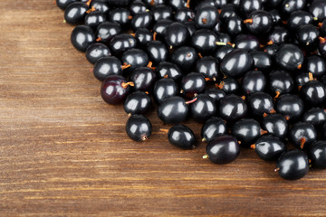 Heap of wild black currant on wooden table close up