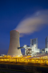 A modern brown coal power station with night blue evening sky.