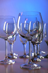 Empty wine glasses on color background
