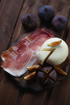 Fresh adygea cheese with ham and ripe fig fruits, studio shot